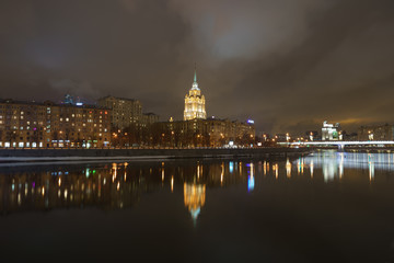 Fototapeta premium Hotel Ukraine (Radisson Royal Hotel) in bright lights and Moskva river in night winter reflections of the night Moscow.