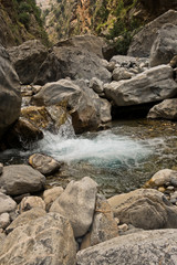 Crystal clear water of a cold mountain creek at rocky terrain of Samaria gorge, south west part of Crete island, Greece