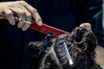 Naklejka premium Primer plano de peluquero peinando y cortando el pelo a una mujer