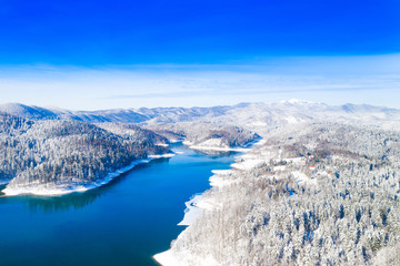Beautiful winter panoramic landscape in mountains, Lokvarsko lake in Croatia, woods under snow in...