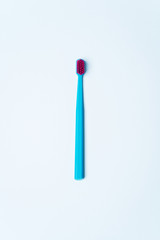 Colorful tooth brushes with bright color bristles on a light pastel blue background. Dental tools with empty space for text for  your mockup.