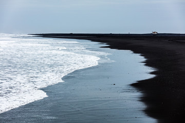 Schwarzer Sandstrand mit Effusivgestein
