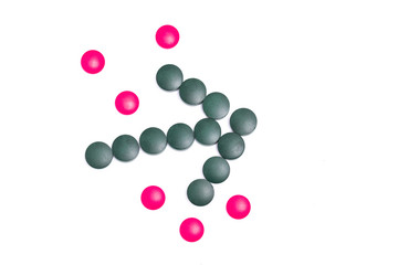 green and pink pills on white background