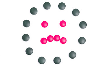 green and pink pills on white background