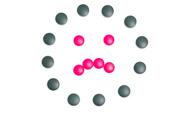 green and pink pills on white background