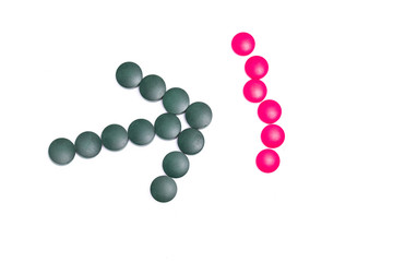 green and pink pills on white background