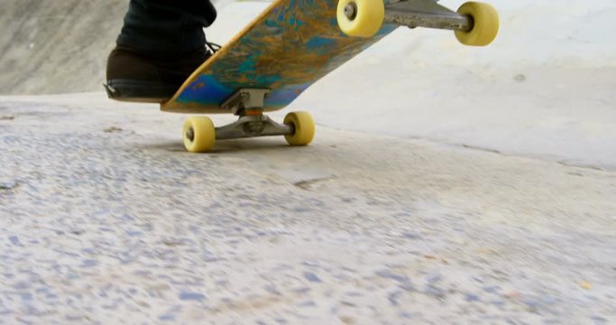 Low section of young man doing skateboarding trick on ramp in skateboard park 4k