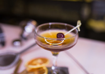 Top view of brown rum Cocktail drink with orange slice cinnamon tools barman beverage on a bar counter . Selective focus on the glass . Trendy stylish edit. Copy paste background service concept