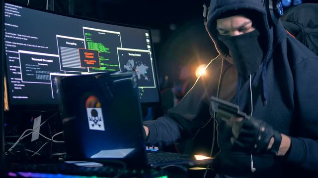Male hacker steals information from credit card. Cyber attack concept.