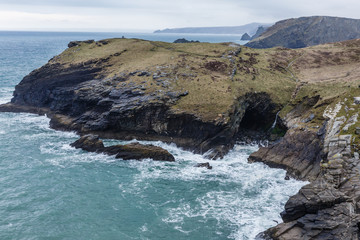 a top-down view of a rocky bay and a mountain behind a large ravine; sea view with a huge mountain on which only grass, lichens and moss grow