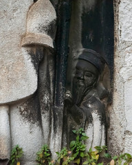 Fototapeta premium Carving of an oriental styled figure as he peeps out from around a larger statue at The Cathedral of Saint Domnius, part of the Diocletian Palace