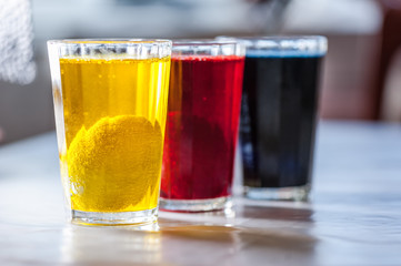 Glasses with paint for Easter eggs. Easter Egg decorating. Close up, soft focus. Step of painting process. Homemade.
