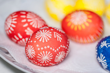 Hand painted easter eggs on white paper napkin. Close up, soft focus. Homemade. The process of painting eggs with wax.
