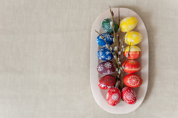 Easter background. Eggs in wooden plate, painted with wax and food colors. Close up, soft focus, top view. Easter holiday concept.