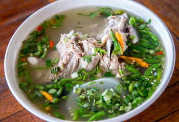 Hot and Spicy Soup with Pork Ribs. Spicy Pork with Pork bone Soup on the Wood Table. Leng soup in Thai word. Hot and spicy pork spare rib soup with tamarind and Thai herbs in bowl, Tom yum.
