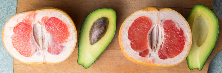 Panorama of grapefruit and avocado on the kitchen board