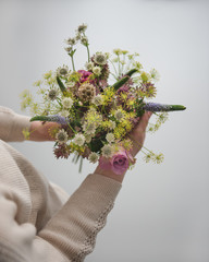 Frau hält bunten Frühlingsstrauss in der Hand 