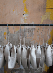 Viele Stoffbeutel ordentlich nebeneinander an einer Kleiderstange 