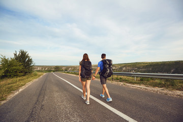 Obraz premium Travelers with backpacks go on the road in nature