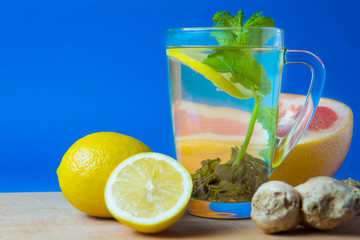 Green tea with lemon, ginger, grapefruit, mint. Blue background