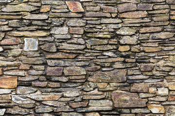 stone wall fragment, flat size stones of different sizes, thickness, width making a beautiful structure in different colors
