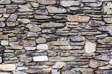 stone wall fragment, flat size stones of different sizes, thickness, width making a beautiful structure in different colors