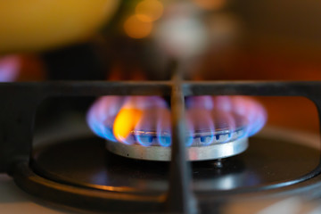 Blue flame of a burning gas stove burner. Close-up, selective soft focus