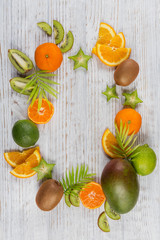 Green palm leaves and fresh tropical slices of fruits