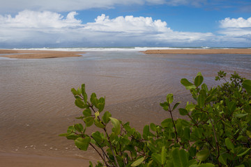 Calm beach of Brazil. The sea and the clouds merge on the horizon.