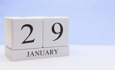 January 29st. Day 29 of month, daily calendar on white table with reflection, with light blue background. Winter time, empty space for text
