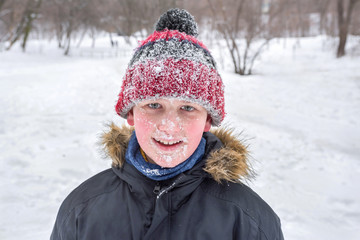 Fototapeta premium A boy’s portrait in winter time. A close-up. The whole face in the snow.