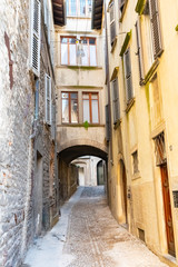 Fototapeta na wymiar Beautiful Old narrow street of small medieval city Citta Alta, perspective of street in Bergamo, Italy