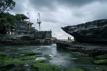 Obraz premium BALI, INDONESIA - November 21, 2013: Hindu Temple Pura Tanah Lot, a popular tourist and cultural icon located on a rock formation, during sunset with dramatic skies.