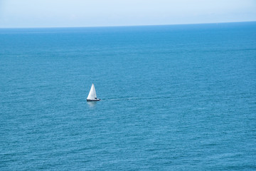 Obraz premium Sailboat floats alone on open sea in France at the north coast