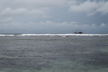 SERANGAN, BALI, INDONESIA - November 26, 2013: Surf at Serangan Beach on a rainy day.