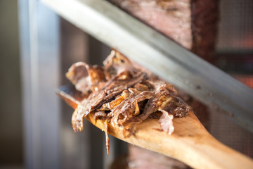 Turkish Doner Kebab, Shawarma or Gyros. Chef cutting with doner knife Traditional Turkish Doner Kebab meat, shawarma or gyros. Turkish, greek or middle eastern arab style doner kebab food spit.