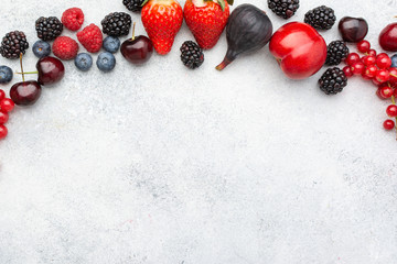 Colorful berries background. Strawberries blueberries red currant blackberries raspberries, top view on white table, selective focus