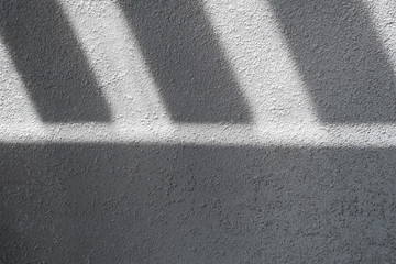 Fototapeta premium Shadow and light through blinds window on tiled wall. Abstract form morning light and shadow on the wall.