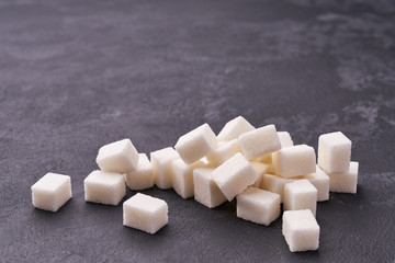 White sugar cubes  on black background close-up.