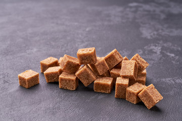Brown sugar cubes  on black background close-up.