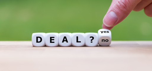 Deal or no deal? Hand turns a dice and changes the word "no" to "yes".