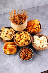 Salty snacks. Pretzels, chips, crackers in wooden bowls.