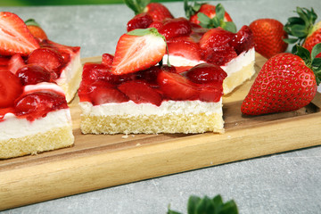 strawberry cake and many fresh strawberries on grey background table