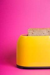 yellow toaster on a pink background
