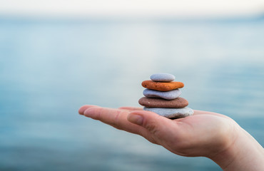 Pile of stacked stones in human hand