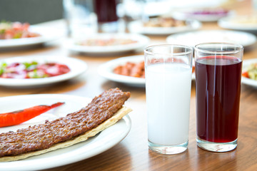 Traditional Turkish Adana Kebab or kebap meat food, raki and salgam in Turkish Restaurant with salad