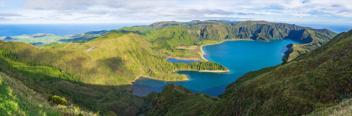 Wide Panoramic landscape with beautiful blue crater lake Lagoa do Fogo from viewpoint Miradouro da Lagoa do Fogo. Lake of Fire is the highest lake of Sao Miguel island, surrounded by Natural Reserve