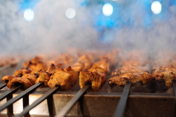 Chicken shish Kebab or kebap meat on metal skewer barbecue and embers in the Turkish restaurant....