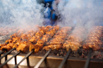 Chicken shish Kebab or kebap meat on metal skewer barbecue and embers in the Turkish restaurant....