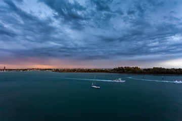 Fototapeta premium Thunderstorm dark clouds over Sant'Elena island in the Venice lagoon with boat sailing